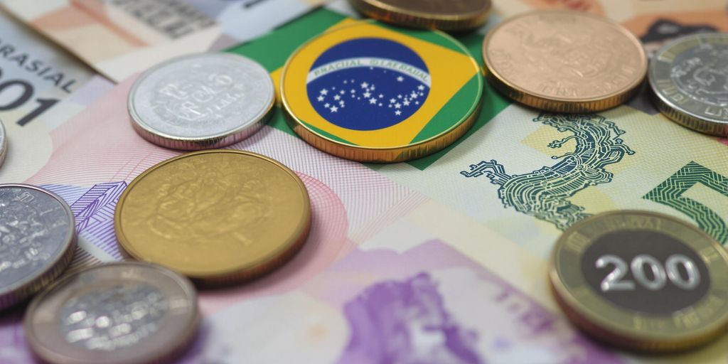 Notas e moedas brasileiras em close-up.